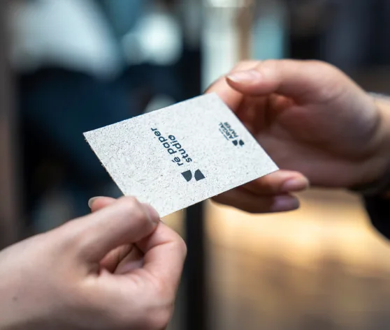 A Ré Paper business card being handed over